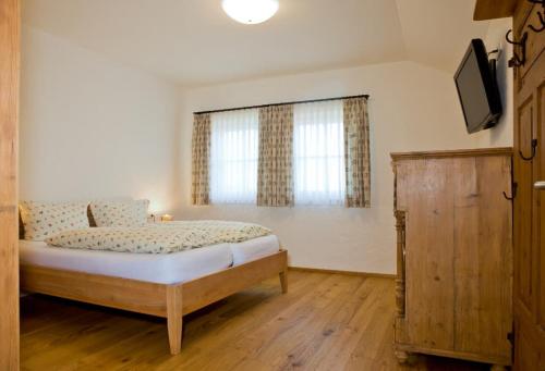 a bedroom with a bed and a television in it at Ferienhof "Schoppa-Haisl" in Sonnen