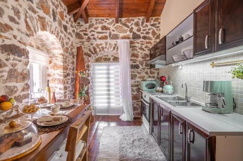 a kitchen with a counter and a stone wall at Stirida Stone House in Stírion