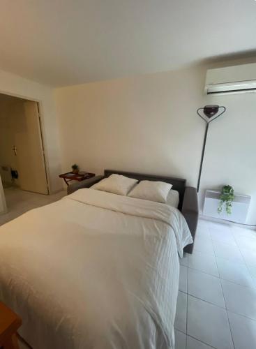 une chambre avec un lit blanc et une lampe dans l'établissement Cœur de Nice, à Nice