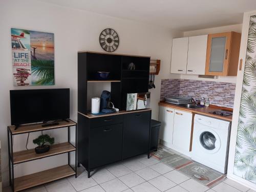 Il comprend une cuisine équipée d'un lave-linge et une télévision. dans l'établissement Appartement vue mer latéral, accès direct plage avec parking privé, au Barcarès