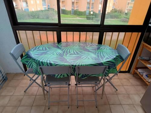 une table et des chaises assises sur un balcon dans l'établissement Appartement vue mer latéral, accès direct plage avec parking privé, au Barcarès