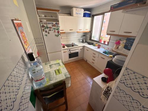 a small kitchen with a table and a refrigerator at Wbs in Almería