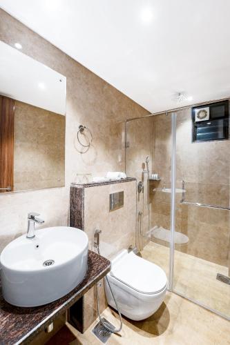 a bathroom with a sink and a toilet and a shower at Holitel Anjuna in Arpora