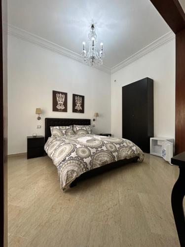 a bedroom with a large bed and a chandelier at B&B Paolo e Mariella in Palermo