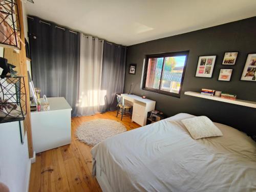 une chambre avec un lit, un bureau et une fenêtre dans l'établissement Maison contemporaine en bois au coeur des Corbières, à Ferrals-lès-Corbières