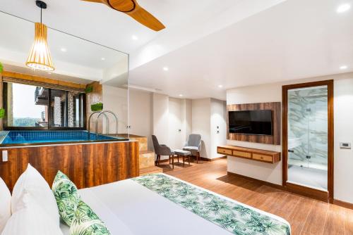 a hotel room with a tub and a bedroom at Holitel Anjuna in Arpora
