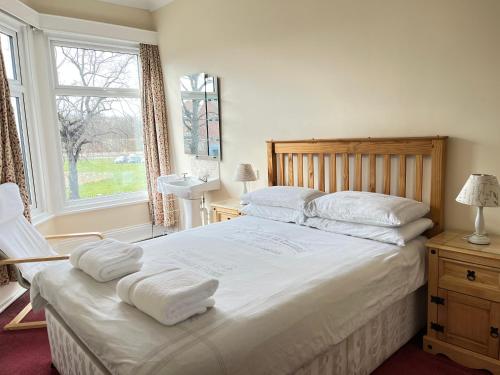 a bedroom with a large bed with towels on it at Chadwick Guest House in Middlesbrough