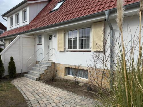 una casa blanca con techo rojo en Ferienhaus Sandmohn, en Kellenhusen