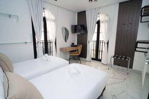 a hotel room with two beds and a table at La Villa Ora in Antibes