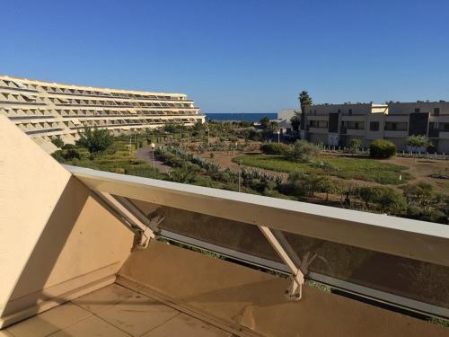 un balcon avec vue sur un immeuble dans l'établissement Appartement 6 personnes Héliopolis - K 204, au Cap d'Agde