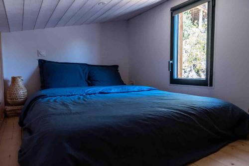 una camera da letto con un letto in una stanza con una finestra di La cabane a Narbonne-Plage