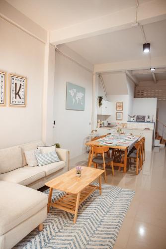 a living room with a couch and a table at Spacious Relaxing Townhouse with Rooftop in Ekamai in Bangkok