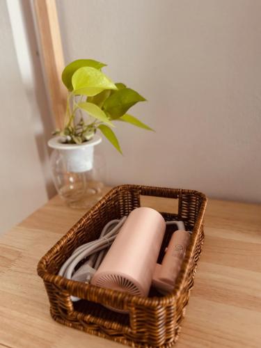 a wicker basket sitting on a table with a plant at Spacious Relaxing Townhouse with Rooftop in Ekamai in Bangkok