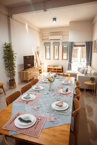 a living room with a table with plates on it at Spacious Relaxing Townhouse with Rooftop in Ekamai in Bangkok