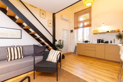 a living room with a couch and a staircase at BudaVibe Apartman w AC by NW in Budapest