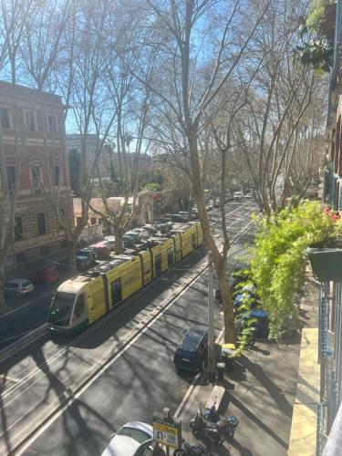 a yellow train on a city street with parked cars at Guest House Esty in Rome