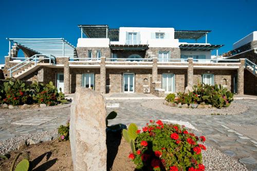 a large stone building with flowers in front of it at Sofia's Bungalows Mykonos in Mýkonos City