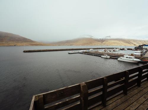 a dock with boats docked in a body of water at Neystastova - Boathouse Stay with Fjord Views in Hvalvík