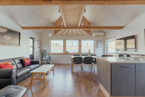 a kitchen and living room with a couch and a table at Neystastova - Boathouse Stay with Fjord Views in Hvalvík