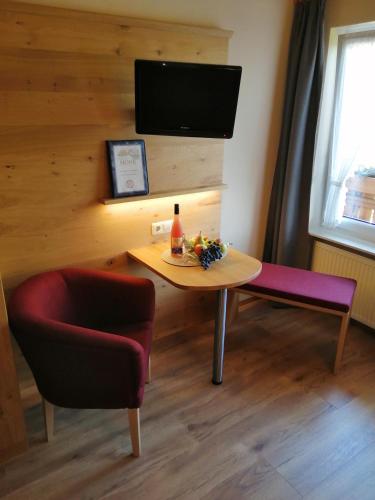 a room with a table and a chair and a tv at Ferienhof Mohr in Meersburg