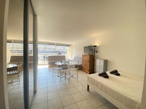 une chambre avec un lit, une table et des chaises dans l'établissement Lumière d'Héliopolis, Avec Vue Mer, Climatisation, au Cap d'Agde