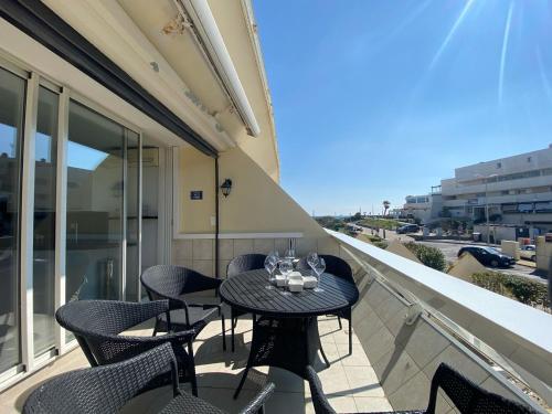 une table et des chaises sur le balcon d'un bâtiment dans l'établissement Lumière d'Héliopolis, Avec Vue Mer, Climatisation, au Cap d'Agde