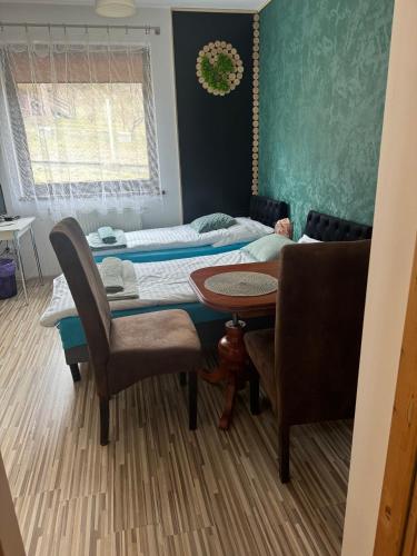 a room with two beds and a table and chairs at Zielona Łąka in Węgierska Górka