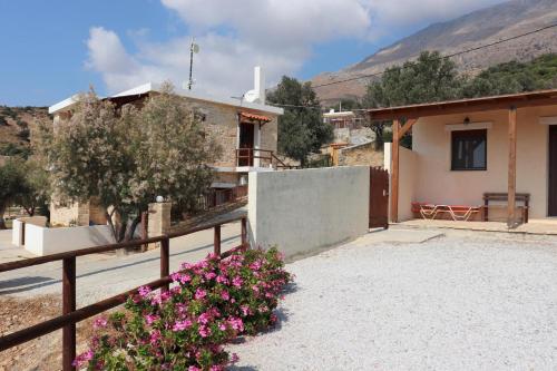 a house with a fence and flowers in front of it at Petra Mare Babis in Akoumia