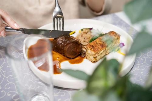 a plate of food with a fork and a piece of cake at Hotel Sladovna in Černá Hora