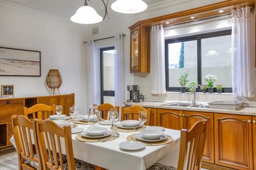 San ĠwannにあるCharming 3BR Maisonette with private Backyard & AC by 360 Estatesのテーブルと椅子のあるキッチンとダイニングルーム