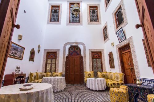 a room with tables and chairs in a building at Riad Dar Bab Guissa in Fès