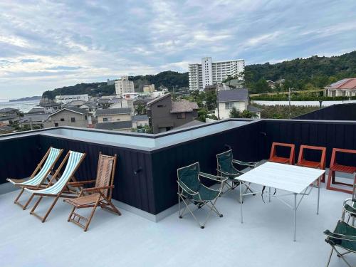 a group of chairs and a table on a roof at Wave Villa with Ocean Views in Onjuku