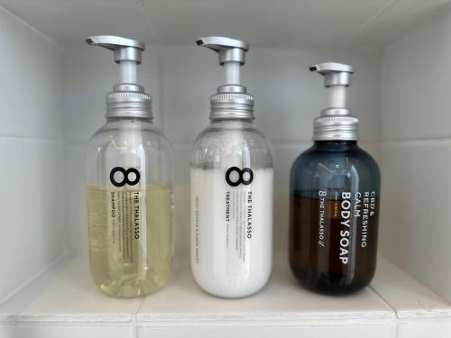 a group of three bottles sitting on a shelf at Wave Villa with Ocean Views in Onjuku