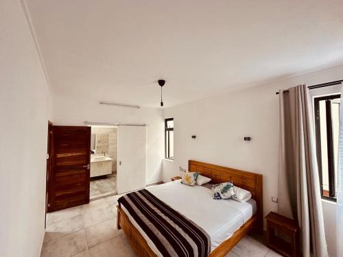 a bedroom with a bed in a white room at Helios Haven in Flic-en-Flac