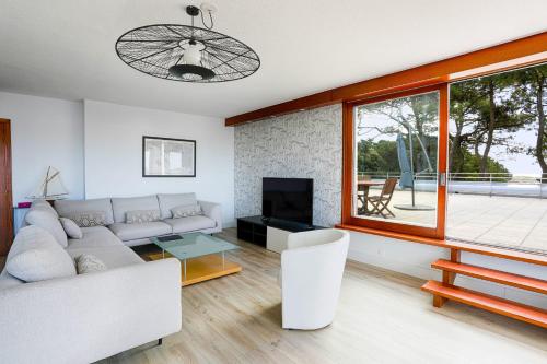 a living room with a couch and a tv at Spacious T4 with Wifi on the seafront in Saint-Philibert