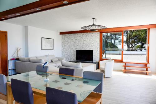 a living room with a table and a couch at Spacious T4 with Wifi on the seafront in Saint-Philibert