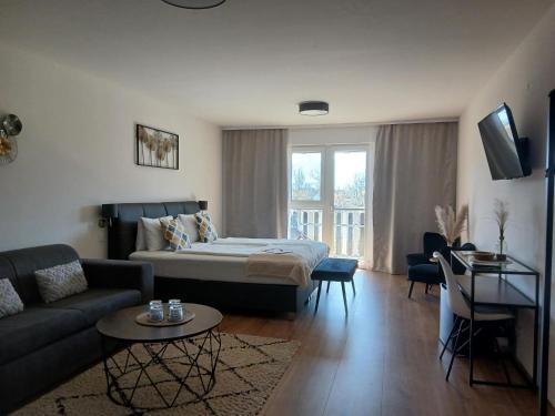 a living room with a bed and a couch at Hotel Fuchs & Hase SELF CHECK IN in Rosegg