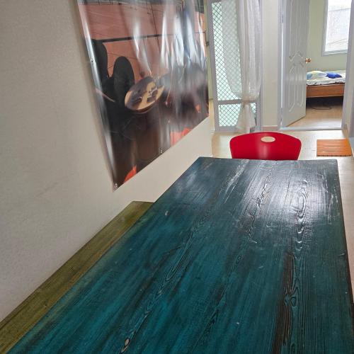 a wooden table in a room with a red chair at Best value, Fresh Air Village in Pohang