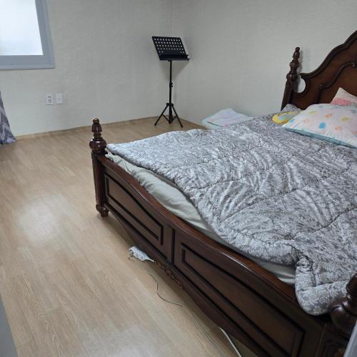 a bed with a wooden frame in a bedroom at Best value, Fresh Air Village in Pohang
