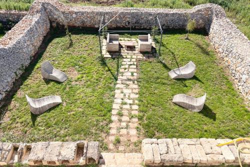 a garden with some chairs and a table and chairs at Masseria Vico in Villaggio Resta