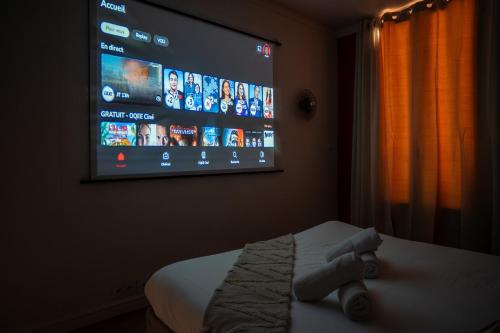 - une télévision à écran plat suspendue au mur dans une chambre dans l'établissement Hypercentre- Confort Premium - Home Cinéma - Parking facile, à Troyes