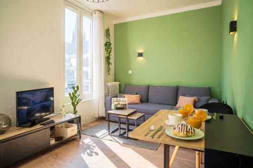 a living room with a couch and a table at Hypercentre- Confort Premium - Home Cinéma - Parking facile in Troyes