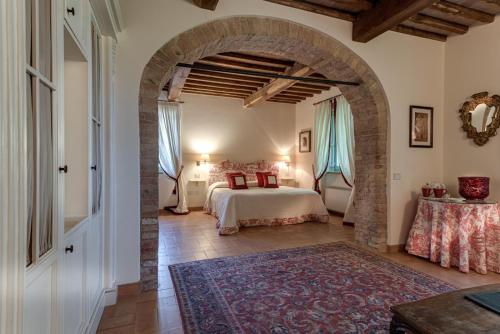 a bedroom with a bed and an archway at Villa il Castagno Wine & Resort in Siena