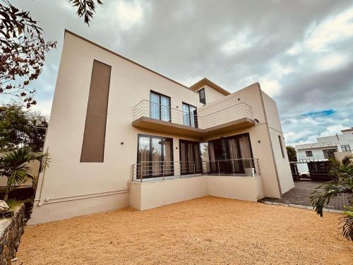 a large white house with a lot of windows at Helios Haven in Flic-en-Flac