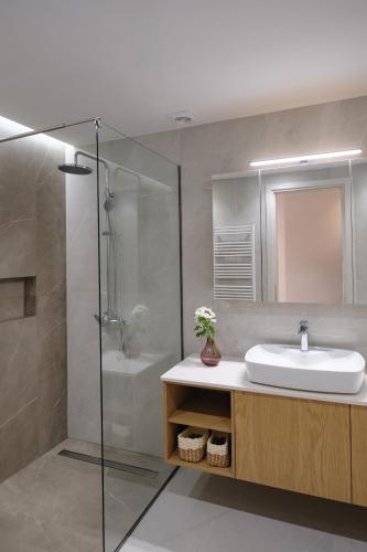 a bathroom with a sink and a shower at Olive Garden House in Gastouri