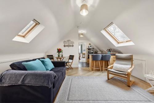 a living room with a blue couch and a kitchen at Beautiful Country Apartment, rated Exceptional in Coventry