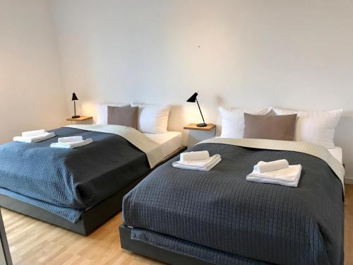 two beds sitting next to each other in a room at The Suites City Lofts at the Park in Hamburg