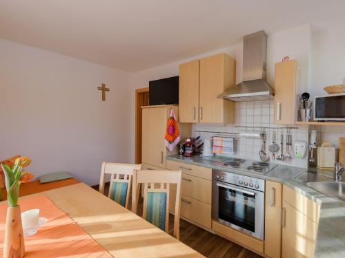 a kitchen with a table and a cross on the wall at Haus Maier in Flachau