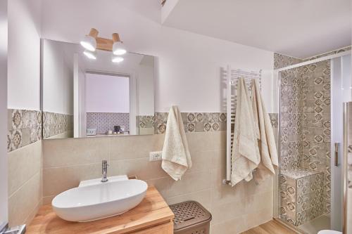 a bathroom with a sink and a mirror and a shower at Zia Marì Casa Vacanze in Palermo