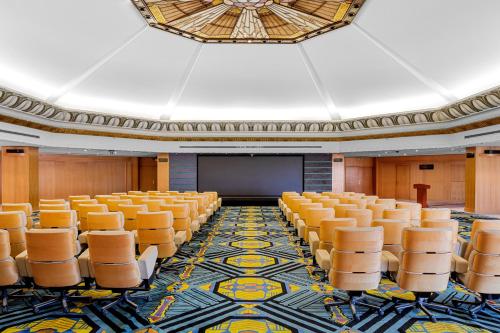 an empty auditorium with orange chairs and a projection screen at Pickalbatros Golf Luxury Suites - All Inclusive in Sharm El Sheikh